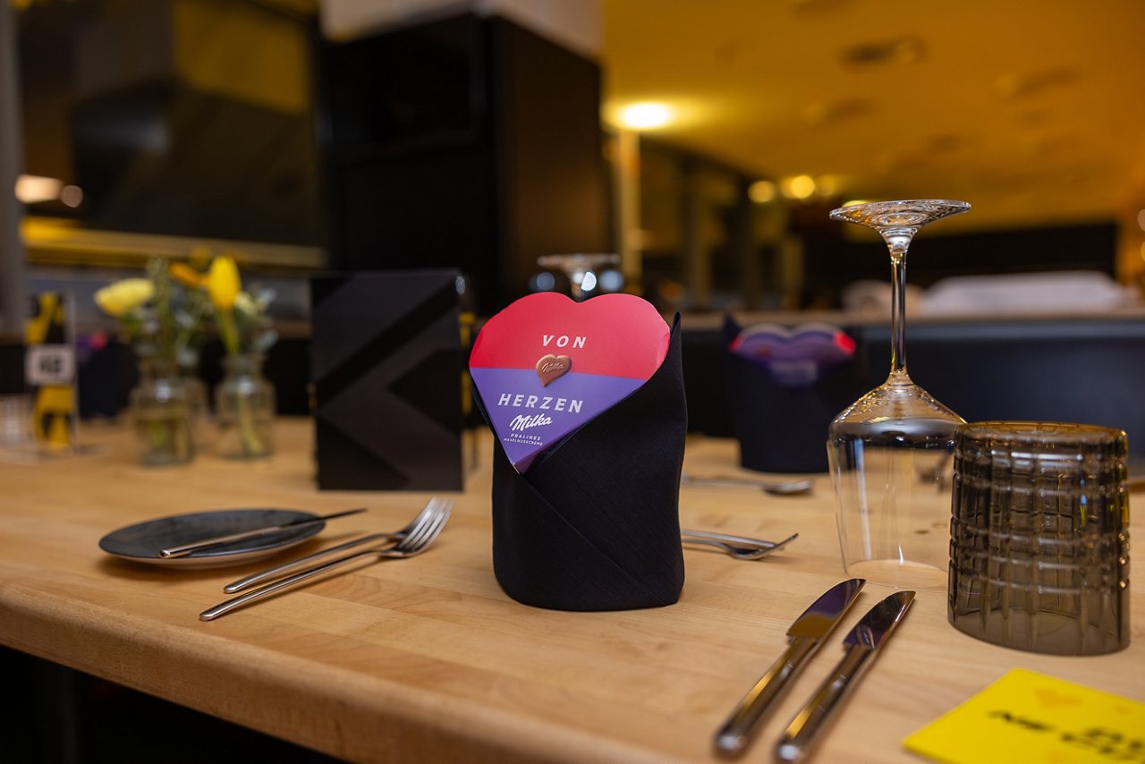 Gedeckter Tisch mit Pralinen in Herzform.