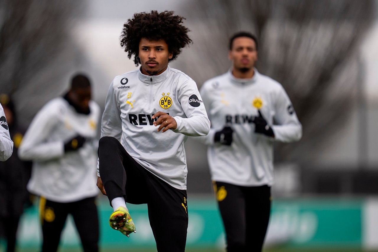 Karim Adeyemi winkelt das rechte Bein an.