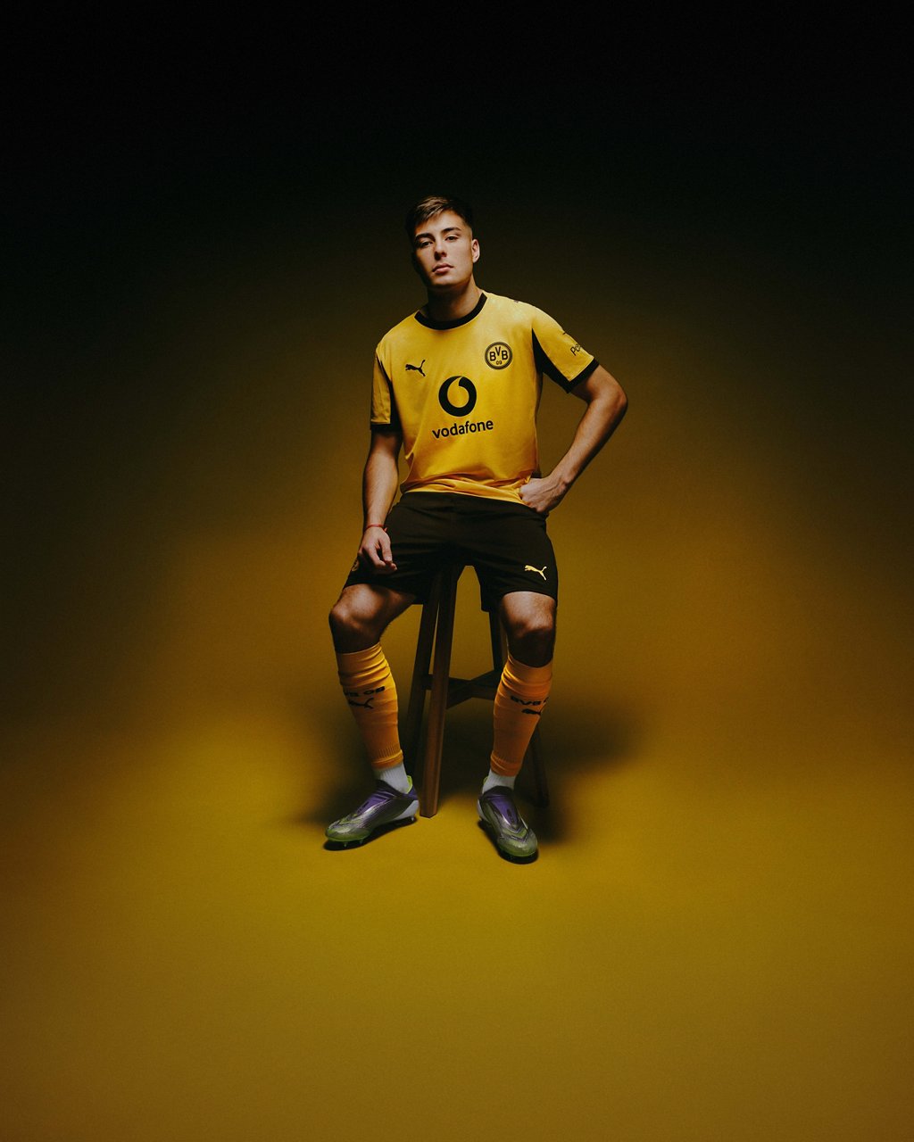 Aaron Anselmino trägt das neue Cup-Trikot und sitzt auf einem Hocker.
