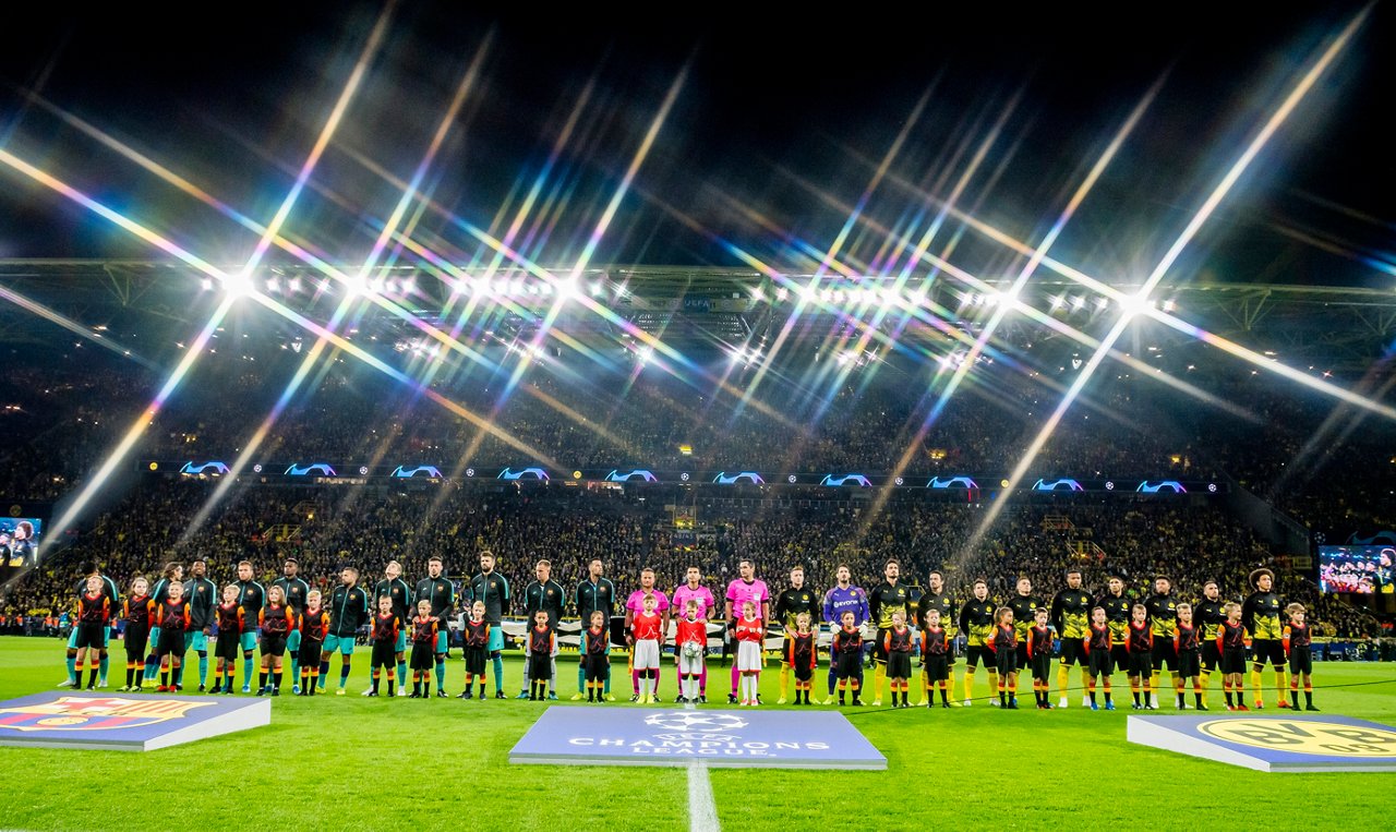 Die Spieler des FC Barcelona, die Schiedsrichter und die Spieler des BVB stehen nebeneinander auf dem Rasen des SIGNAL IDUNA PARK.