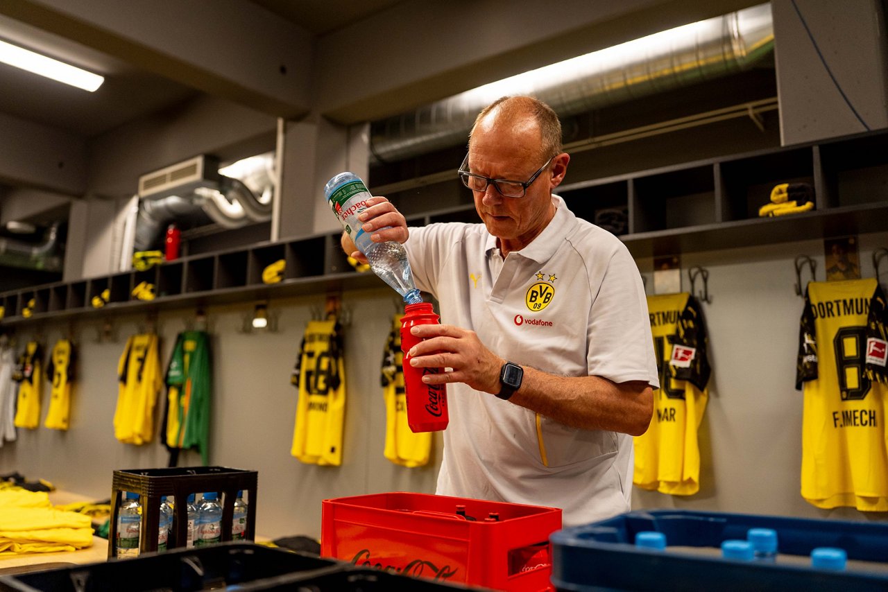 Frank Gräfen füllt in der Mannschaftskabine Wasser in eine Flasche.
