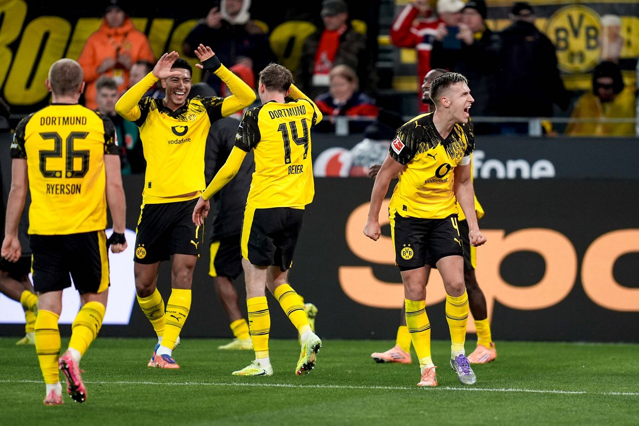 Jobe Bellingham und Maxi Beier schlagen ab. Nico Schlotterbeck jubelt Richtung Fans.