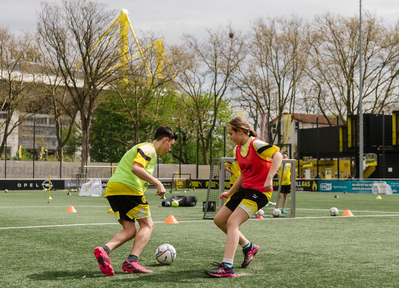 Jugendliche Fans auf dem Rasen des Stadions Roten Erde spielen in Leibchen gegeneinander Fußball