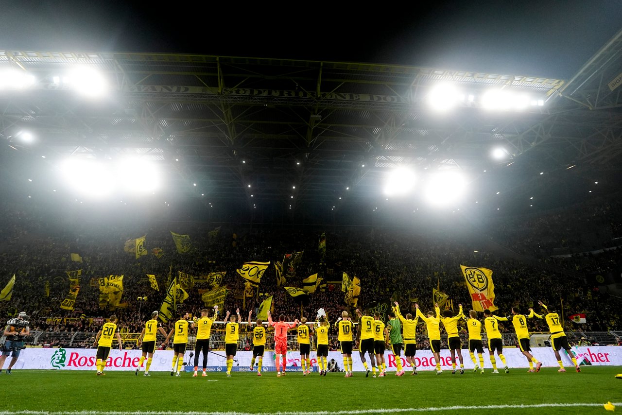 Die BVB-Spieler stehen nebeneinander vor der Südtribüne und feiern mit den Fans.