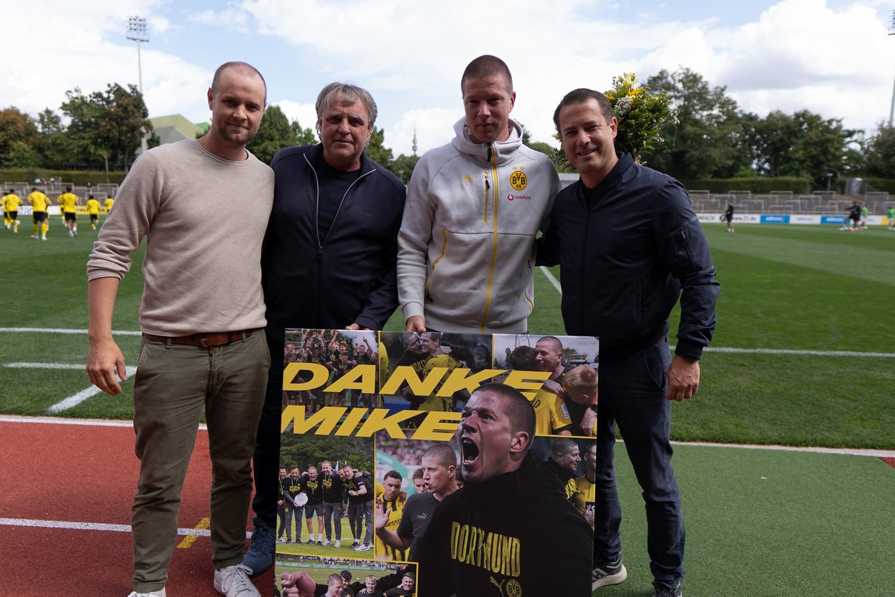 Mike Tullberg posiert mit einer Foto-Collage Arm in Arm mit Lars Ricken, Ingo Preuß und Paul Schaffran.