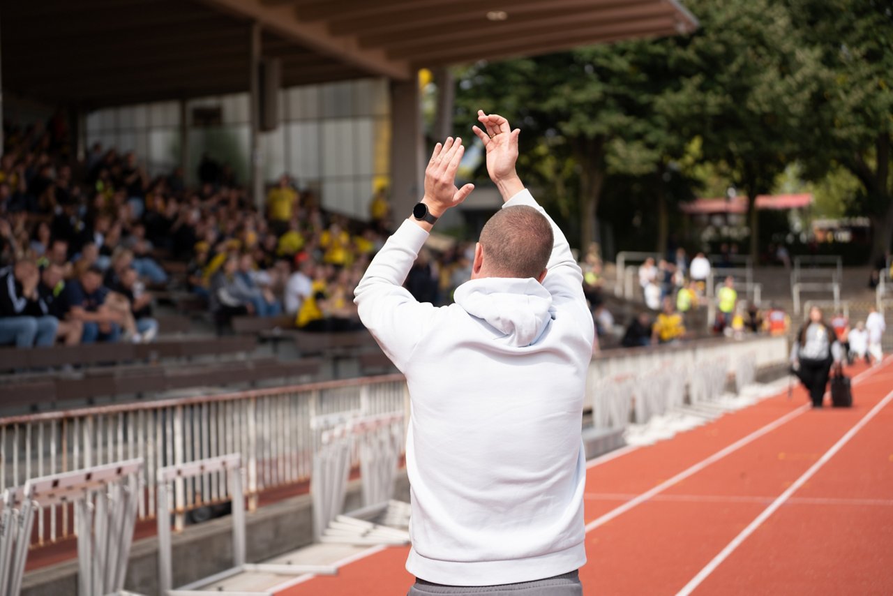 Mike Tullberg klatscht in Richtung Tribüne im Stadion Rote Erde.