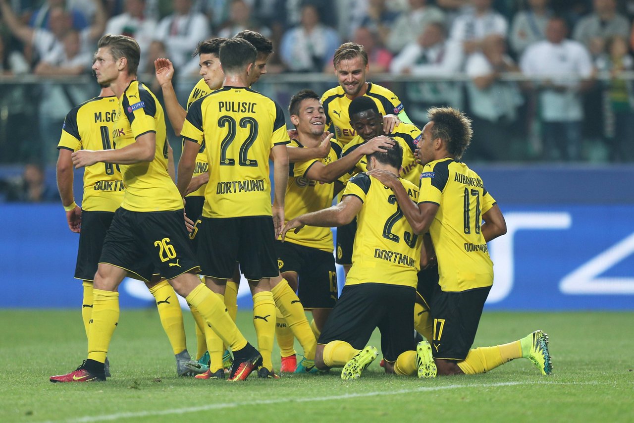 Marcel Schmelzer umarmt seine Teamkollegen, die sich auf den Knien gegenseitig bejubeln.