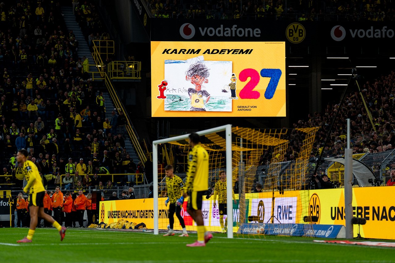 Bildschrim im SIGNAL IDUNA PARK, der von einem Kind gezeichnetes Bild von Karim Adeyemi mit Figuren der Sesamstraße darstellt.