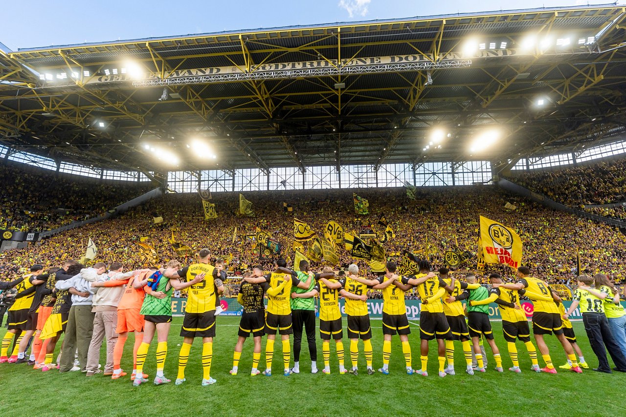 Borussia Dortmund players standing in front of the Yellow Wall.