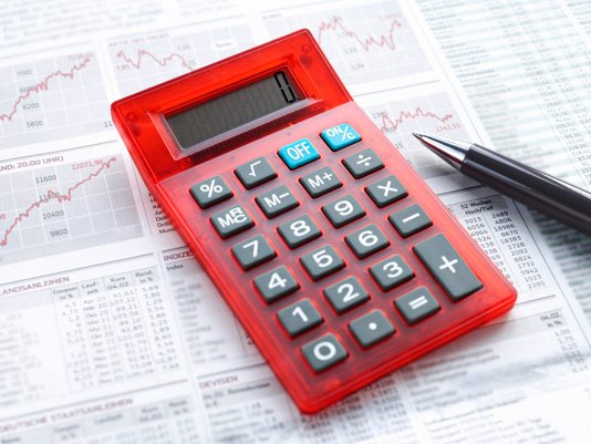 Roter Taschenrechner auf Finanzunterlagen