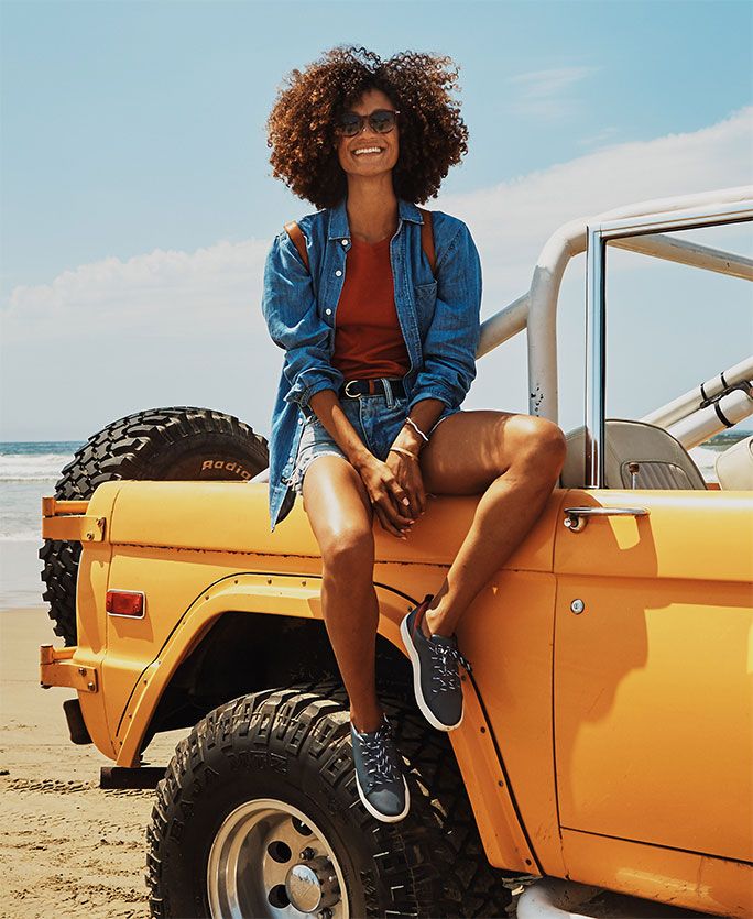 Woman sitting on a yellow car