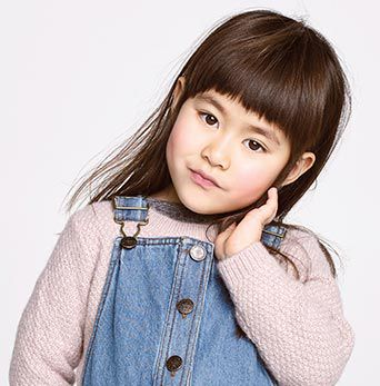 A young girl wearing dungarees