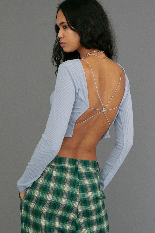 Woman wears blue open back top with green check trousers
