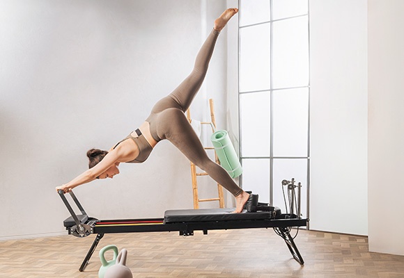 Ženska na pilates reformerju