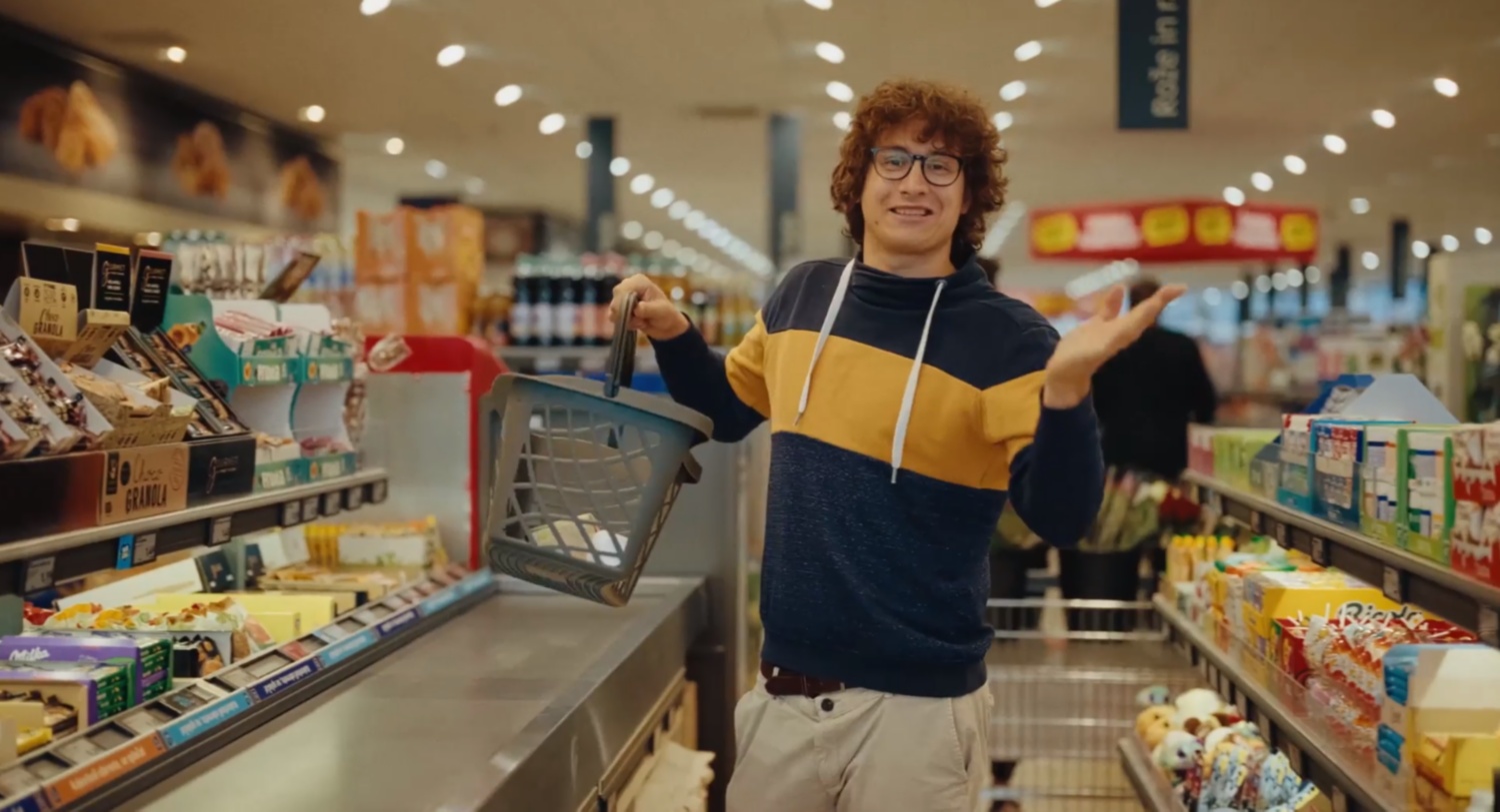 Moški z nakupovalno košarico v roki znotraj Hofer trgovine