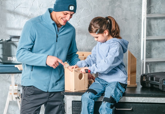 Moški in otrok izdelujeta ptičjo hišico