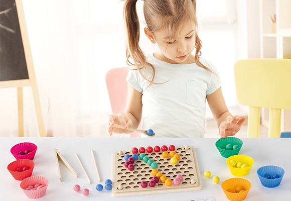 Deklica se igra z namizno igro razvrščanja