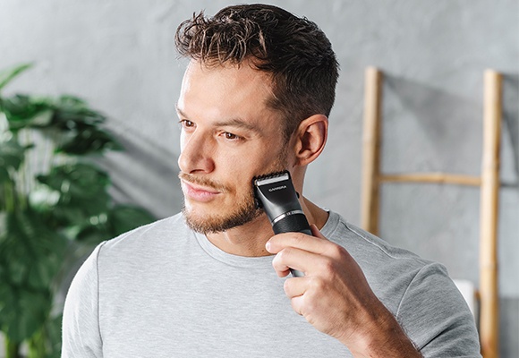 Moški si ureja brado z brivnikom