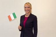 Bettina Hauser, Regionalverkaufsleiterin von HOFER, lächelt in die Kamera und schwenkt eine italienische Flagge.