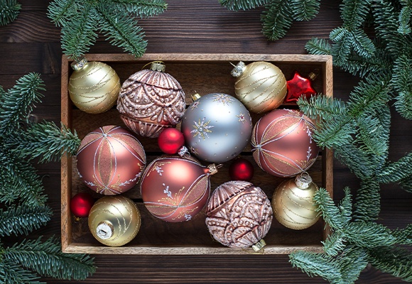 Christbaumkugeln in einer Holzkiste mit Tannenzweigen rundum