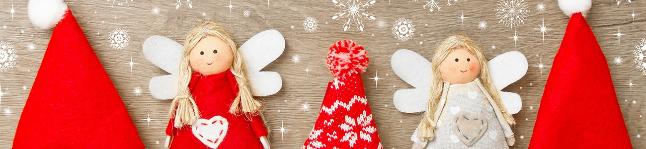 Zwei genähte Christkinder in rot und weiß gekleidet, stehen zwischen roten Zipfelmützen.