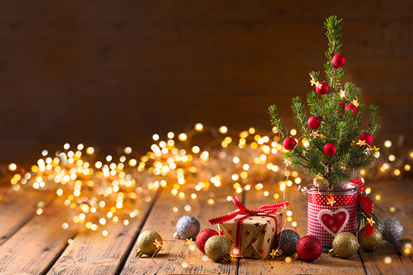 Lichterkette und ein kleiner getopfter Baum mit Chritbaumkugeln.
