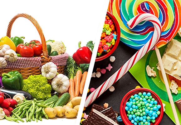 Das Bild ist zweigeteilt. Auf der linken Seite ist Obst und Gemüse zu sehen. Auf der rechten Bildseite sind Süßigkeiten, wie Lollies und ein Zuckerstock.