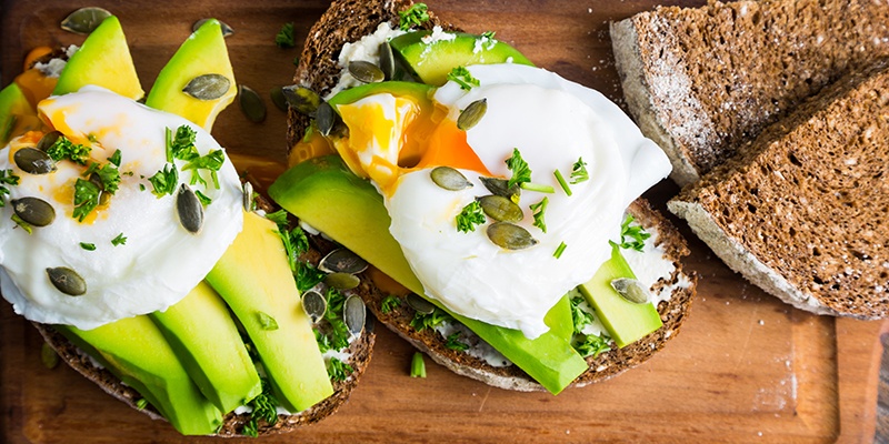 Zwei Brote mit Aufstrich und Avocadospalten.