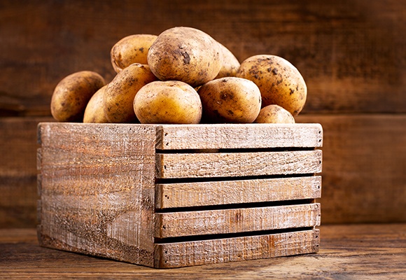 Eine Holzkiste mit Kartoffeln.