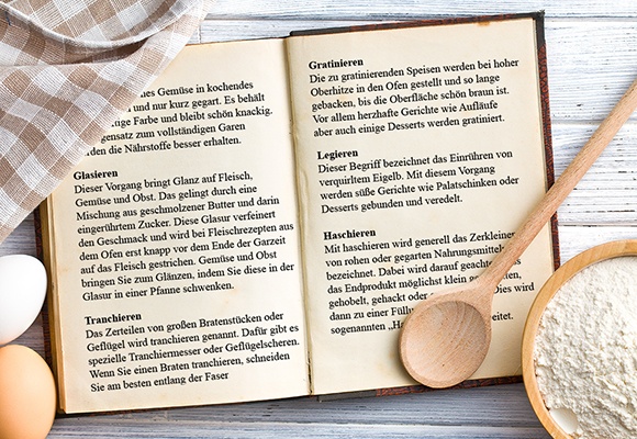 Ein aufgeschlagenes Kochbuch, indem verschiedene Zubereitungsmethoden erklärt werden.