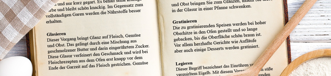 Ein aufgeschlagenes Kochbuch in dem Glasieren, Gratinieren und Legieren erklärt werden.