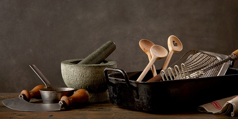 Eine Bratschale mit drei Kochlöffel und anderen Kochutensilien.