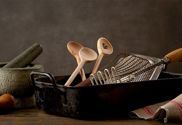 Eine Bratschale mit drei Kochlöffel und anderen Kochutensilien.