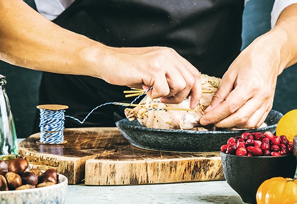 Ein Mann bereitet ein Brathuhn vor.