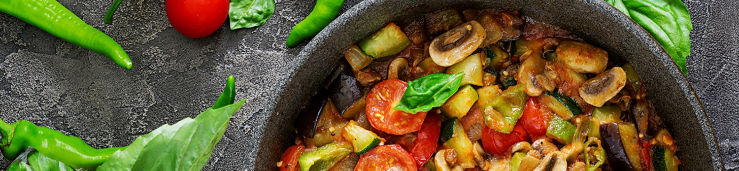 Eine bunte Gemüsepfanne mit Tomaten, Zucchini und Pilzen.