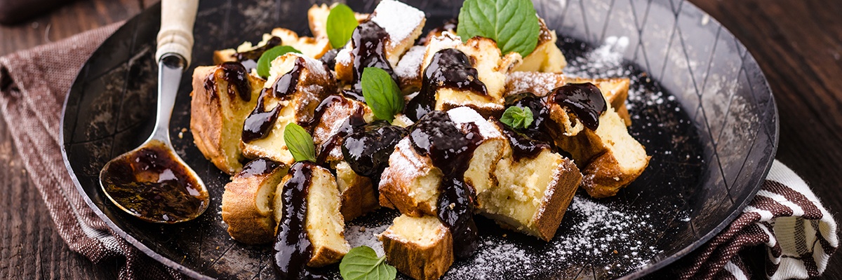 Süßer Teig bestreut mit Puderzucker und Schokoladensoße.