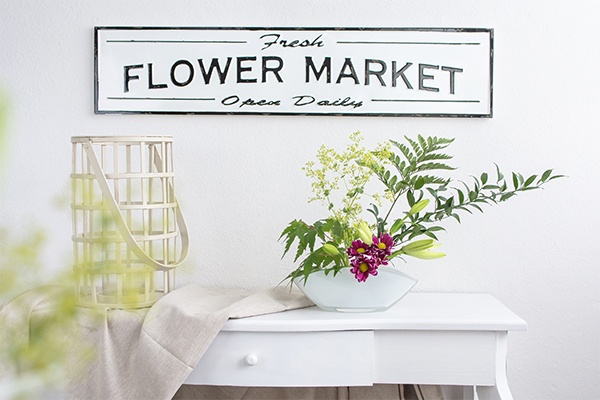 Blumenarrangement als Dekoration auf einer Kommode