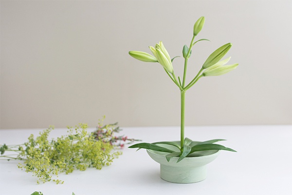 Japanisches Blumengesteck in einer grünen Schale 