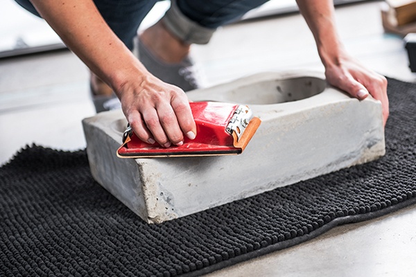 Den getrockneten Beton aus der Form nehmen und abschleifen