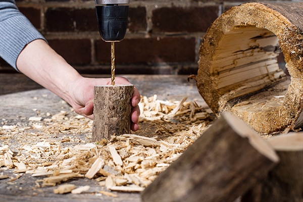 Das DIY-Insektenhotel nach und nach mit Moos und Tannenzapfen verzieren