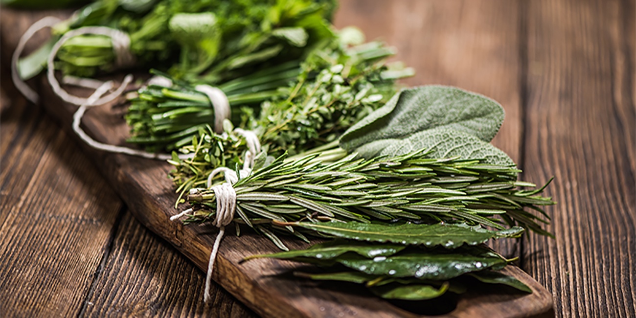 Unterschiedliche Kräuterbündel auf einem Brett 