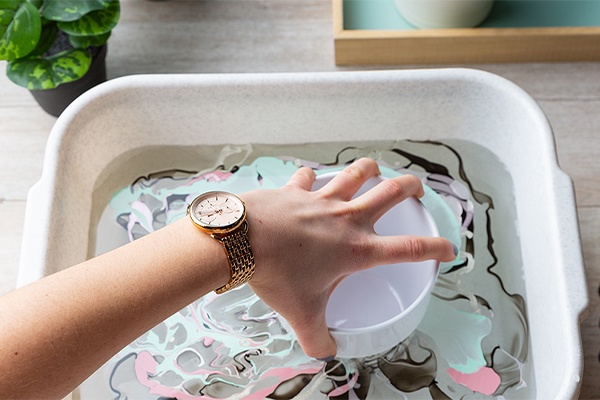 Blumentöpfe in das Wasserbecken mit Nagellack tunken und so einfärben