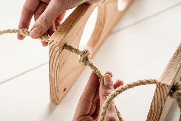 Die einzelnen Etagen aus Holz mit Seilen verbinden  
