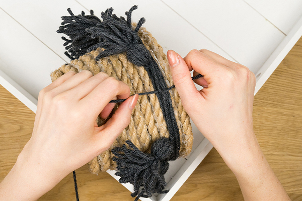 Blumentopf mit schwarzen Kordeln