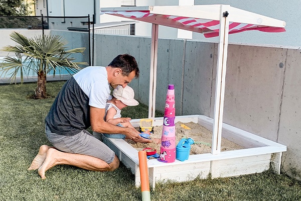 Urlaub auf mit Kind im eigenen Garten kann Spaß machen, zum Beispiel im Sandkasten