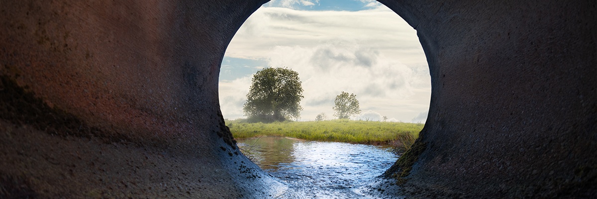 Foto zeigt Abwasserkanal mit Blick auf ein Feld.