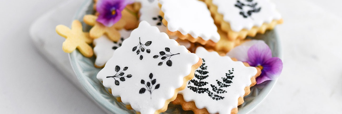 Bestempelte Kekse in einer Schüssel mit lila Blüten
