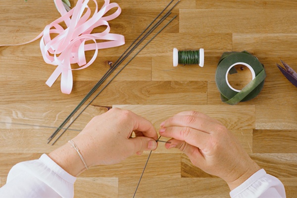 Draht, bunte Bänder und eine Schere. Der Draht wird zusammengedreht