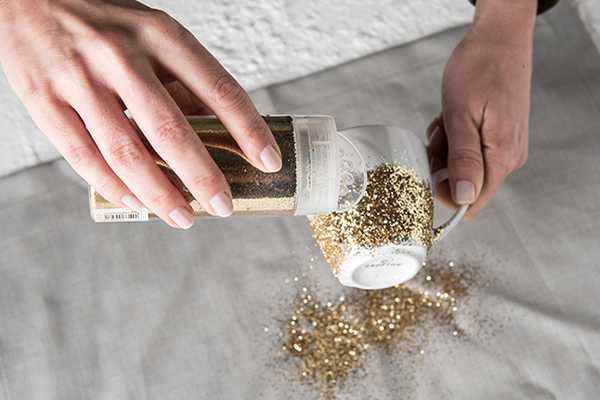 Glitzer wird auf Tasse gestreut
