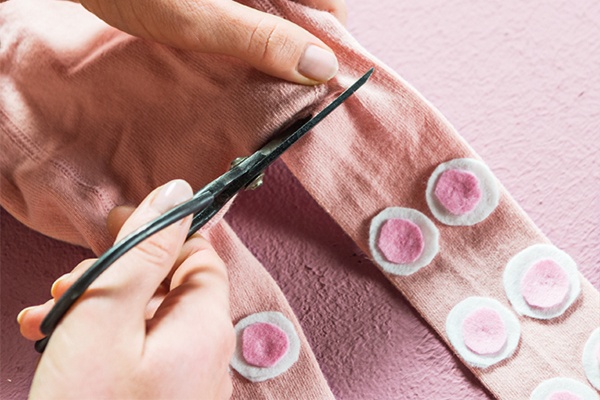 Die Beine der Strumpfhose mit einer Schere trennen